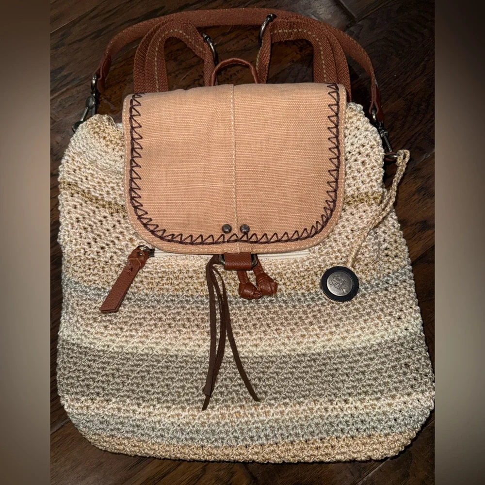 The Sak Crochet Straw Backpack in green and Cream with Brown Trim